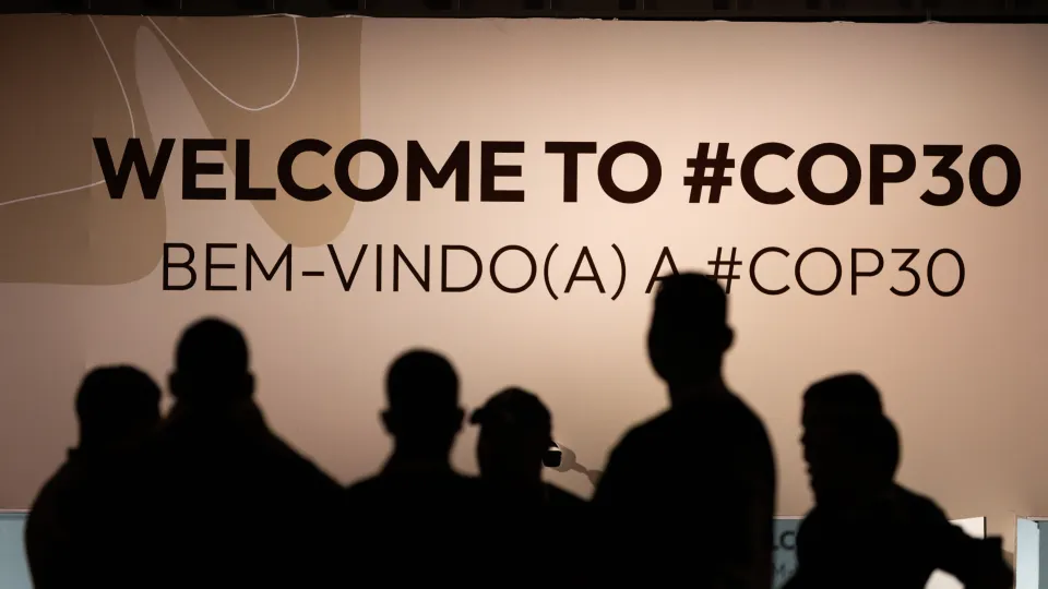 People in front of a sign saying COP30. Photo: UN Climate Change - Kiara Worth.