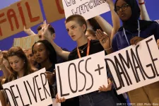 People holding up signs for loss and damage during COP27. Photo: UNFCCC COP27, 2022. Kiara Worth.