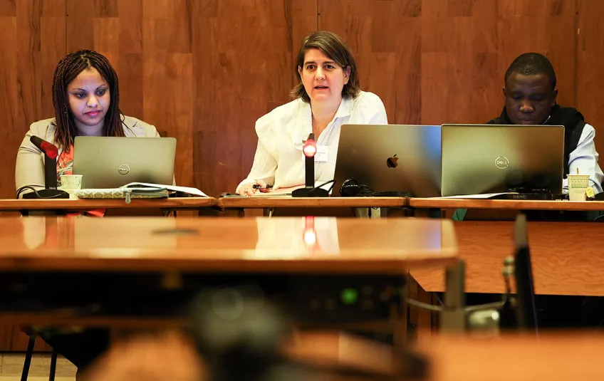 three people in a meeting room. Photo.