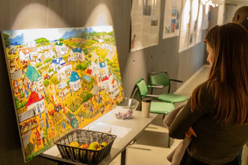 A person looking at a painting on a table.