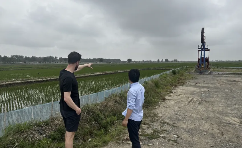 Two men on a field in the Liaohe River Delta. Photo.