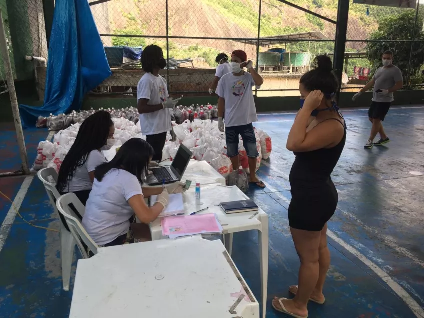 The organisations Utopia and Família na Mesa (“Family around the table”), with the help of local volunteers, are distributing food baskets and personal hygiene kits to residents of the favela of Rocinha. Foto: Alexandre Socci.